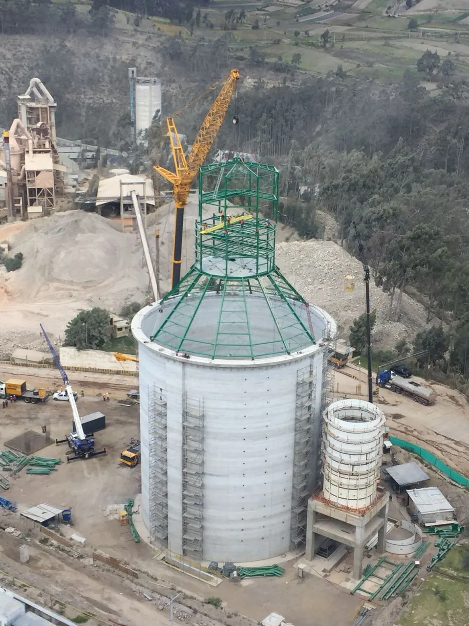 Vista aérea de grúas ejecutando un izaje especial sobre la estructura de un silo industrial en construcción